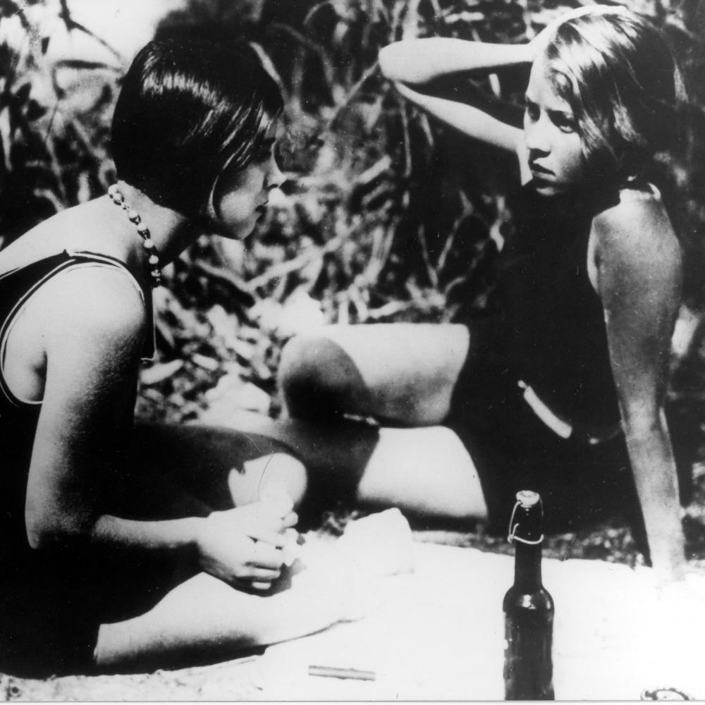 black and white photograph of two women lounging on the ground