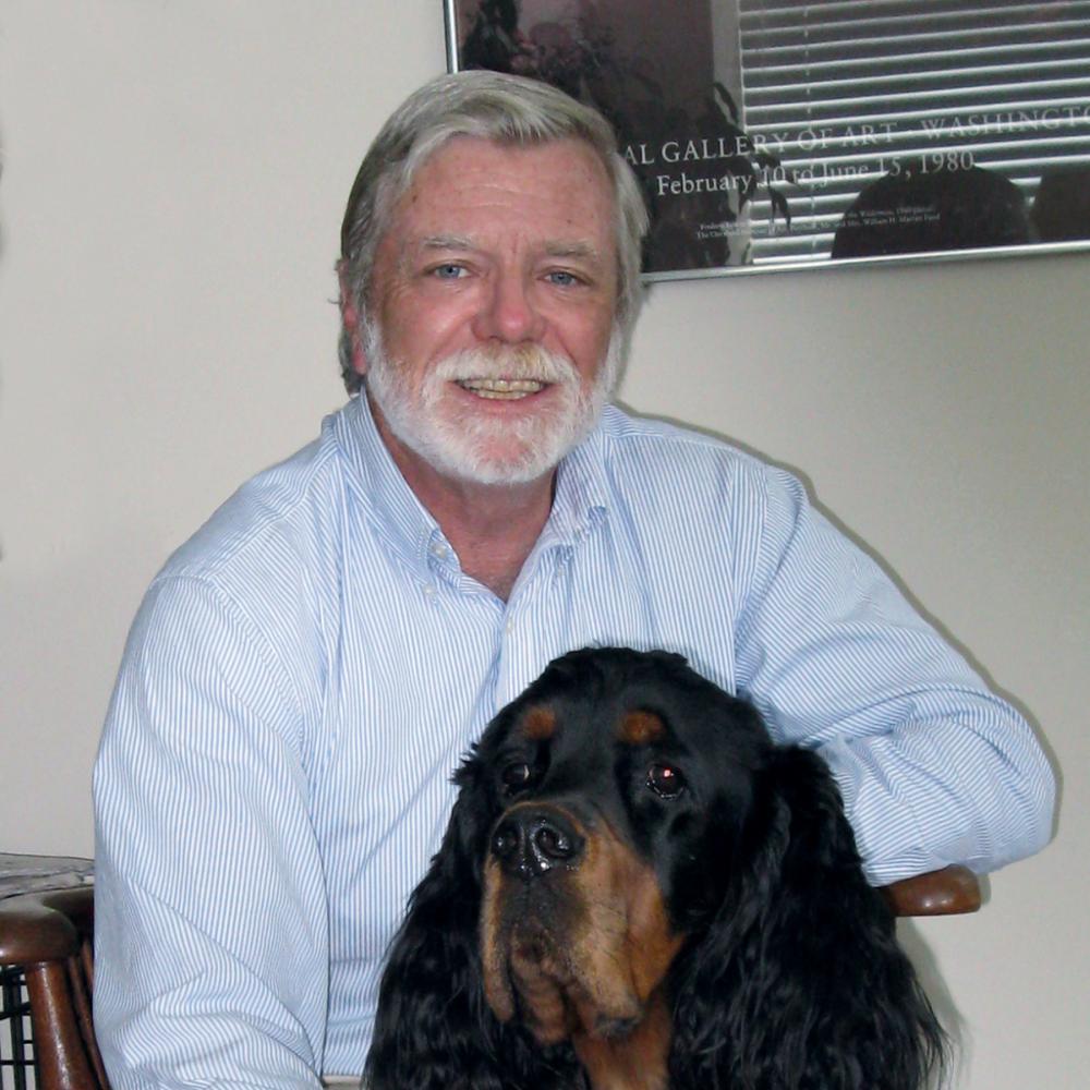 Photograph of man sitting down with dog
