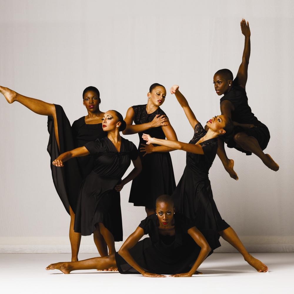 Six women dressed in black, in various dance poses