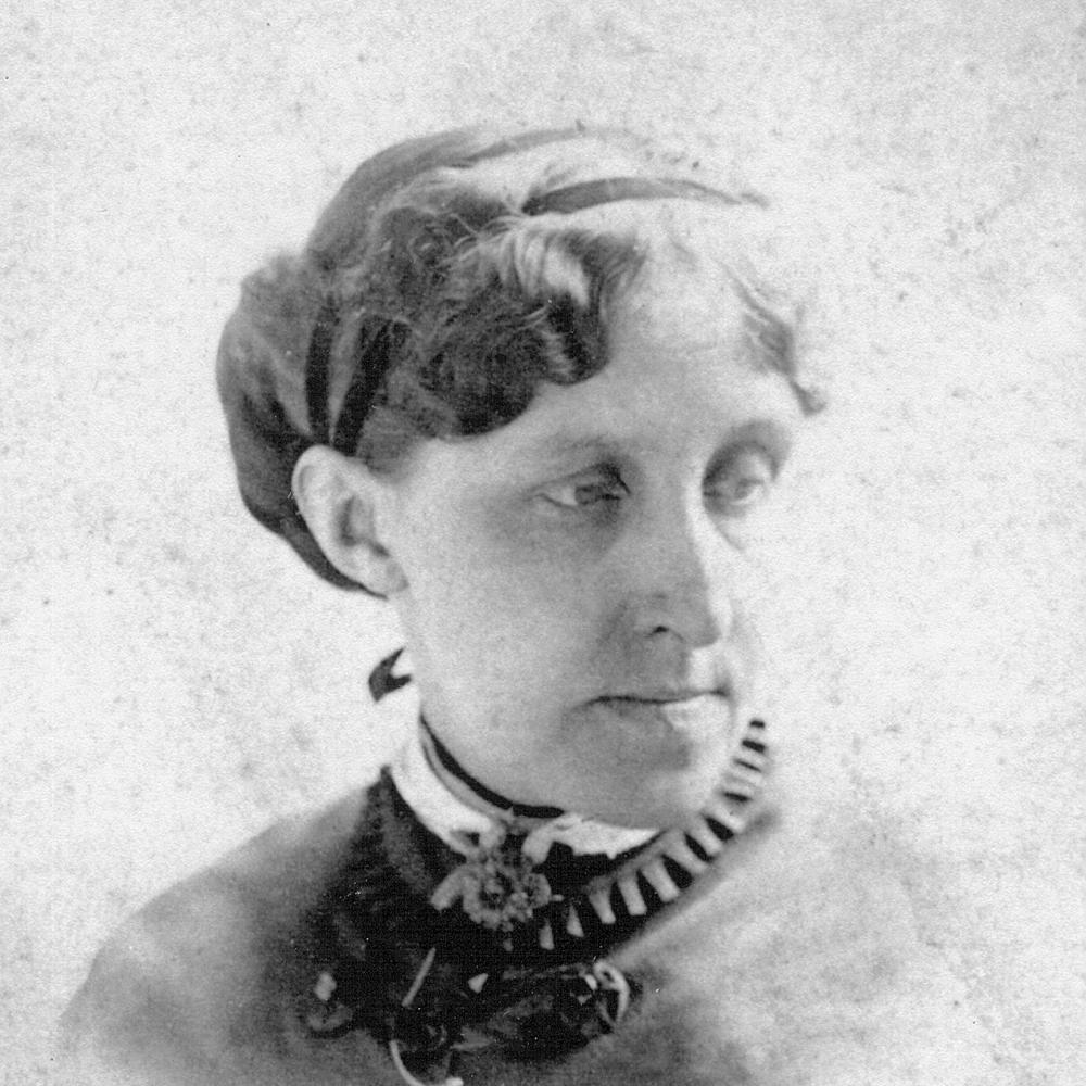 Alcott looking to her left shoulder, wearing a small ruffled collar and dark dress, with her hair in a low chignon