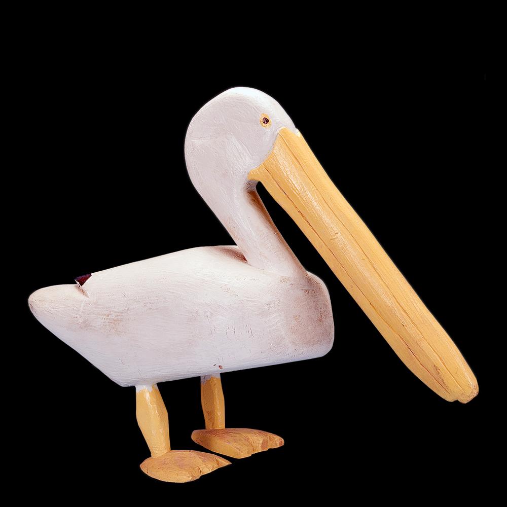 A white pelican with long yellow beak and feet, carved out of wood