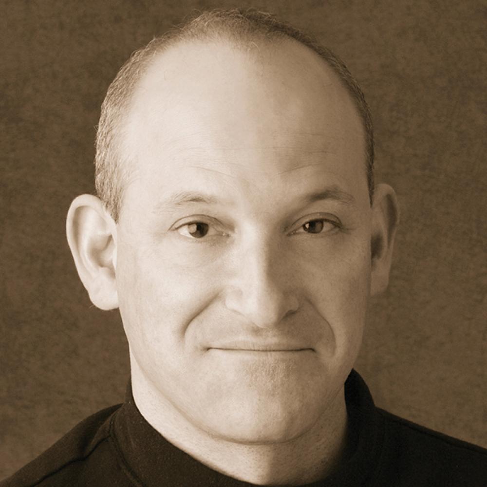 Sepia-colored photo portrait of James Leve wearing a black turtleneck.
