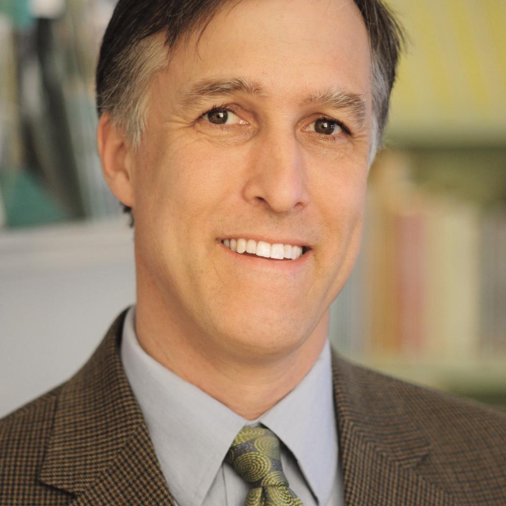 Color photo portrait of Erik Jorgensen in a suit and tie.