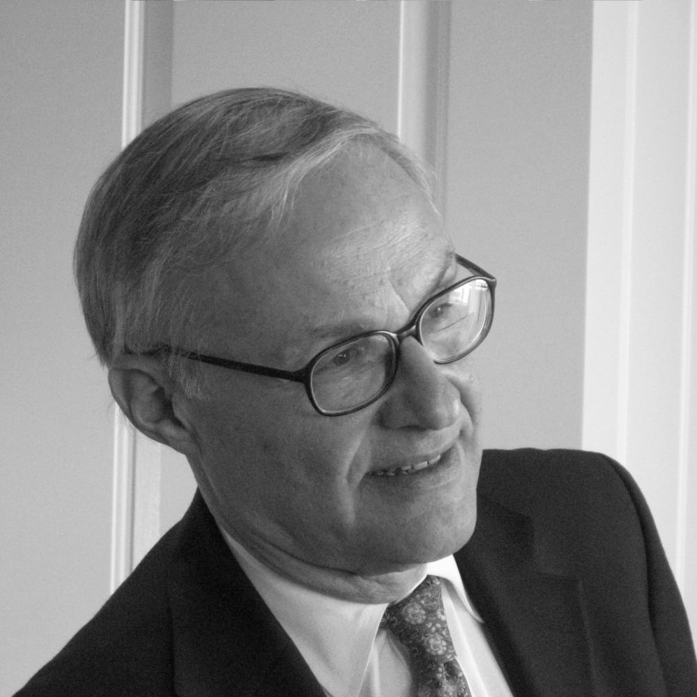 Black and white photo portrait of Leon Kass in a suit and tie.