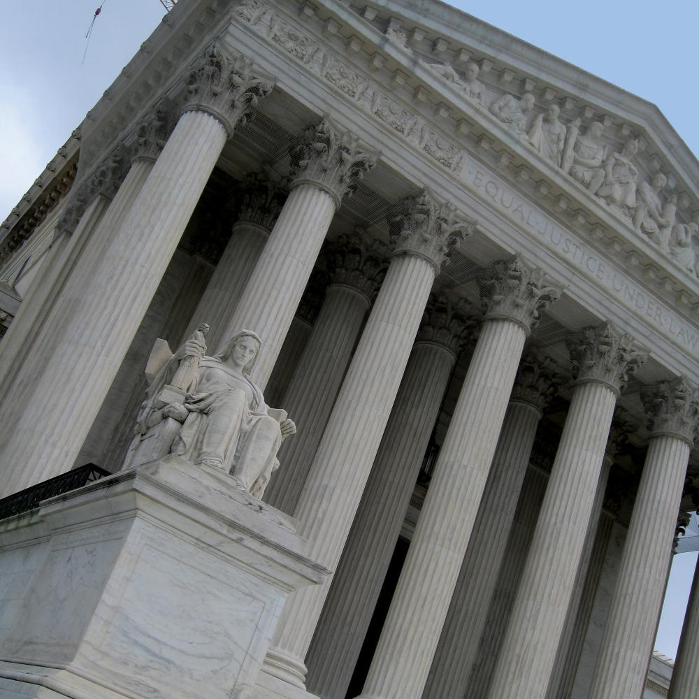 Looking from below up at the supreme court building, with its statue of lady justice on the left