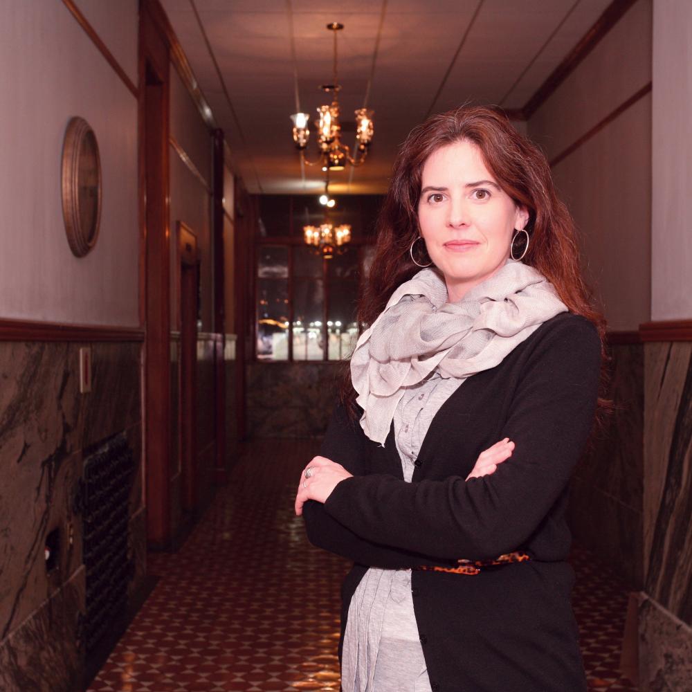 Photograph of a woman standing in a hallway