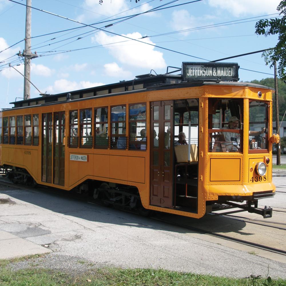 Color photo of a yellow trolley making its way.