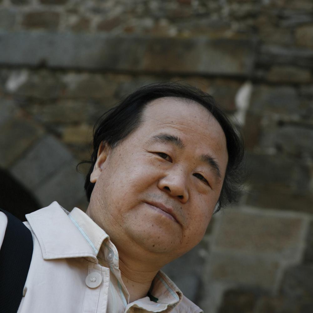 Color photo portrait of Mo Yan in a white collared shirt.