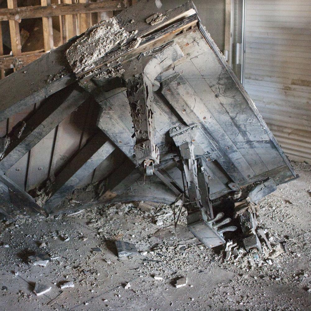 Dusty, run down wooden remains of a piano