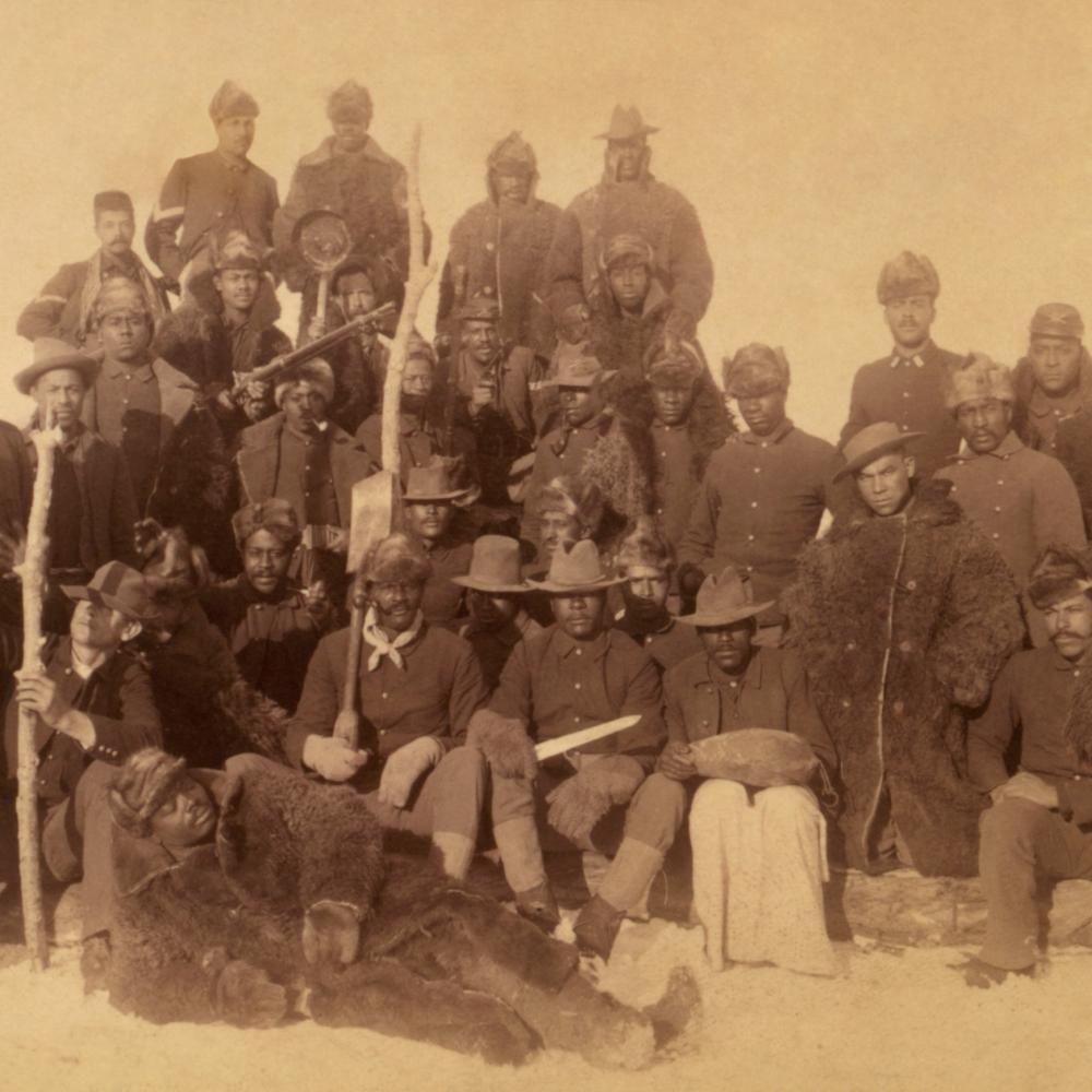 Sepia-colored photo portrait of an African-American infantry unit from the late 19th century.