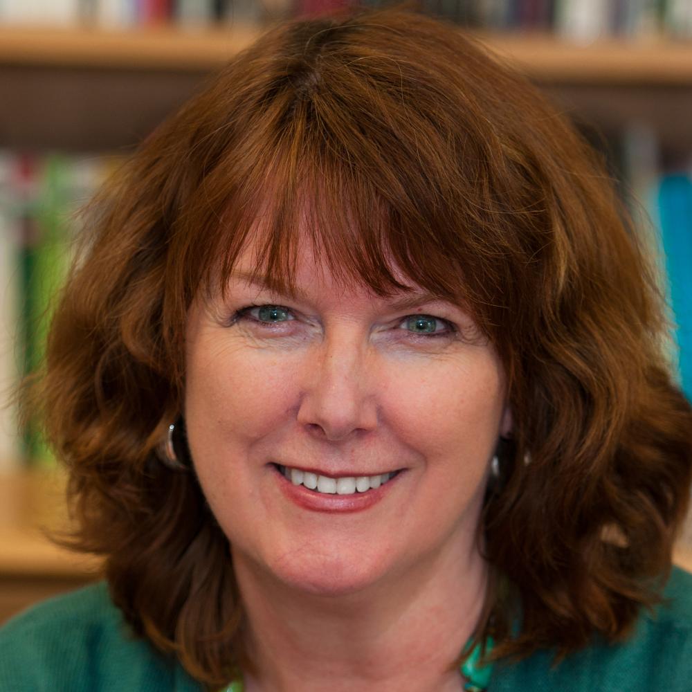 Color photo of Sandra Spanier wearing a green sweater and necklace.