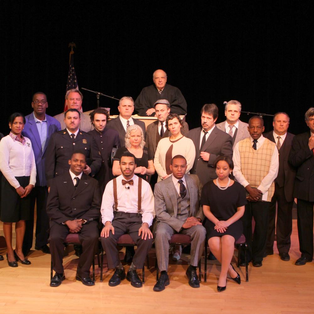Color photo of the cast of a play.