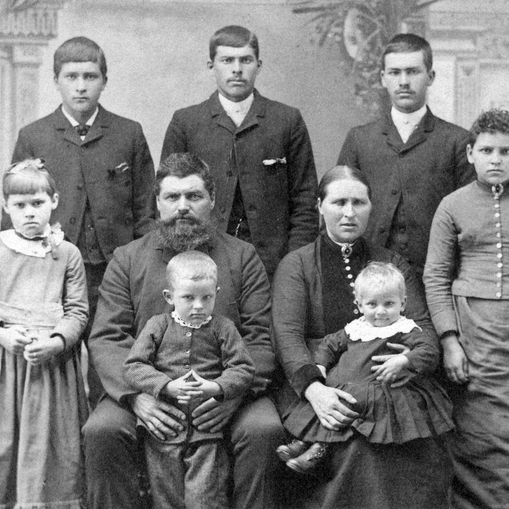 Black and white family portrait of three young children, their parents, and three brothers.