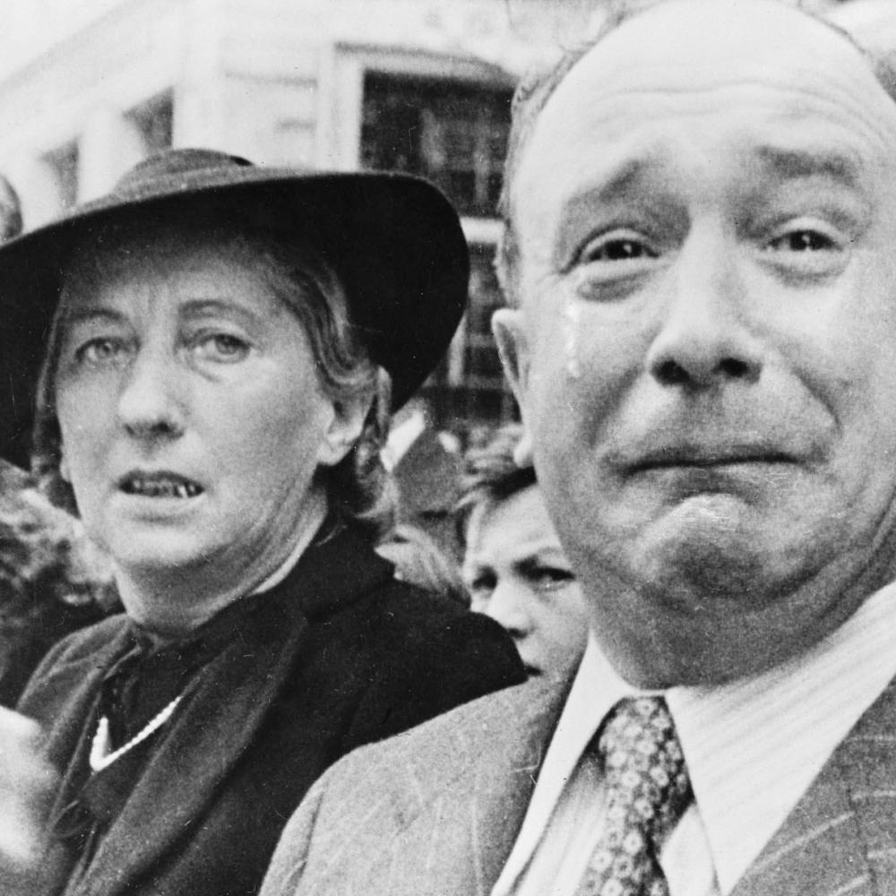 Black and white photo of a man and woman weeping in Paris due to the German occupation.