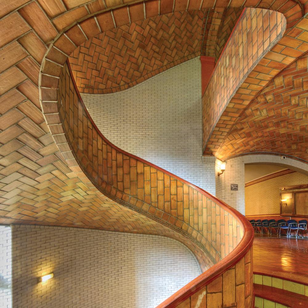 Photo of an ornate, red brick spiral staircase.