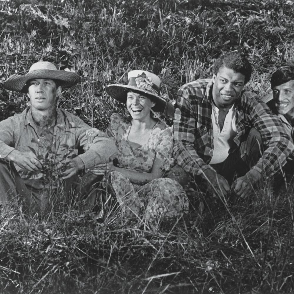 4 of Boxcar Bertha's characters, sitting a grassy field