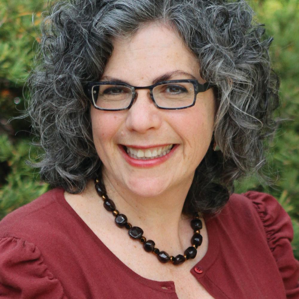 Color photo of Paula A. Michaels wearing glasses and a red blouse.
