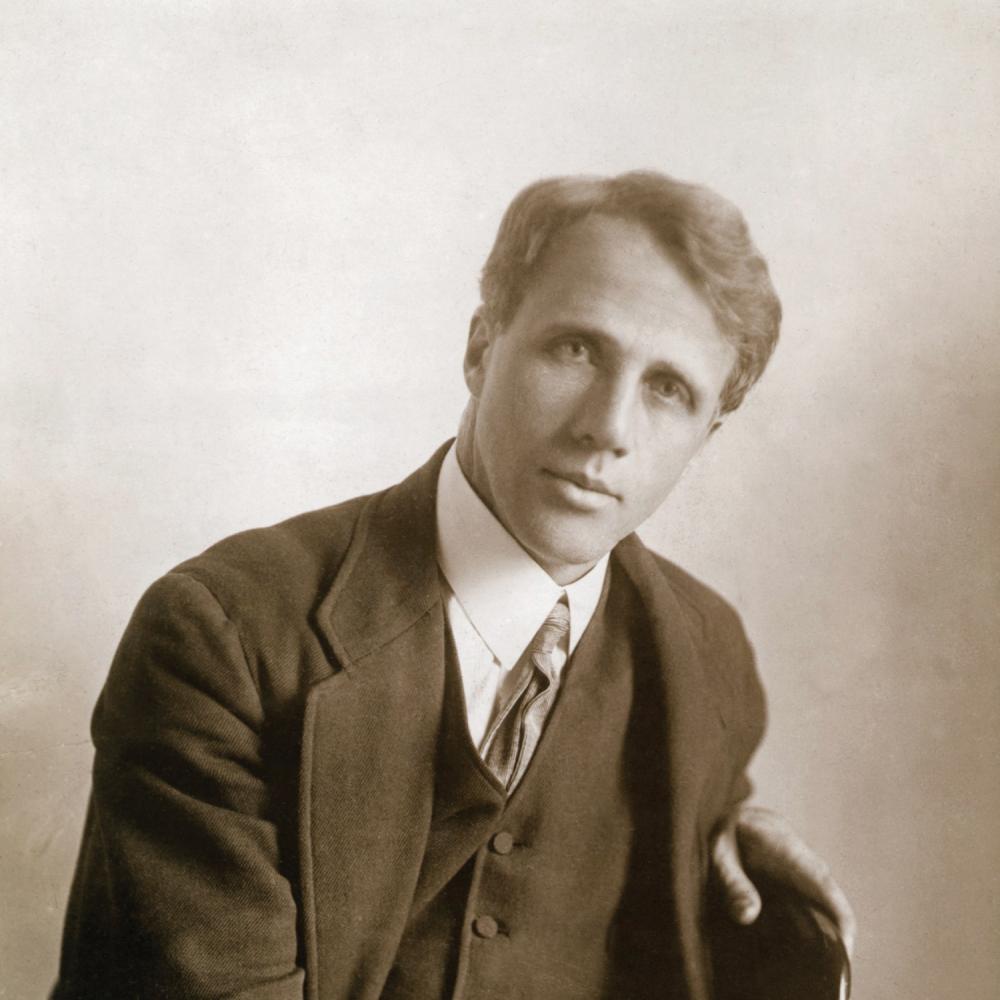 Sepia-colored photograph of a handsome Robert Frost in suit and tie.