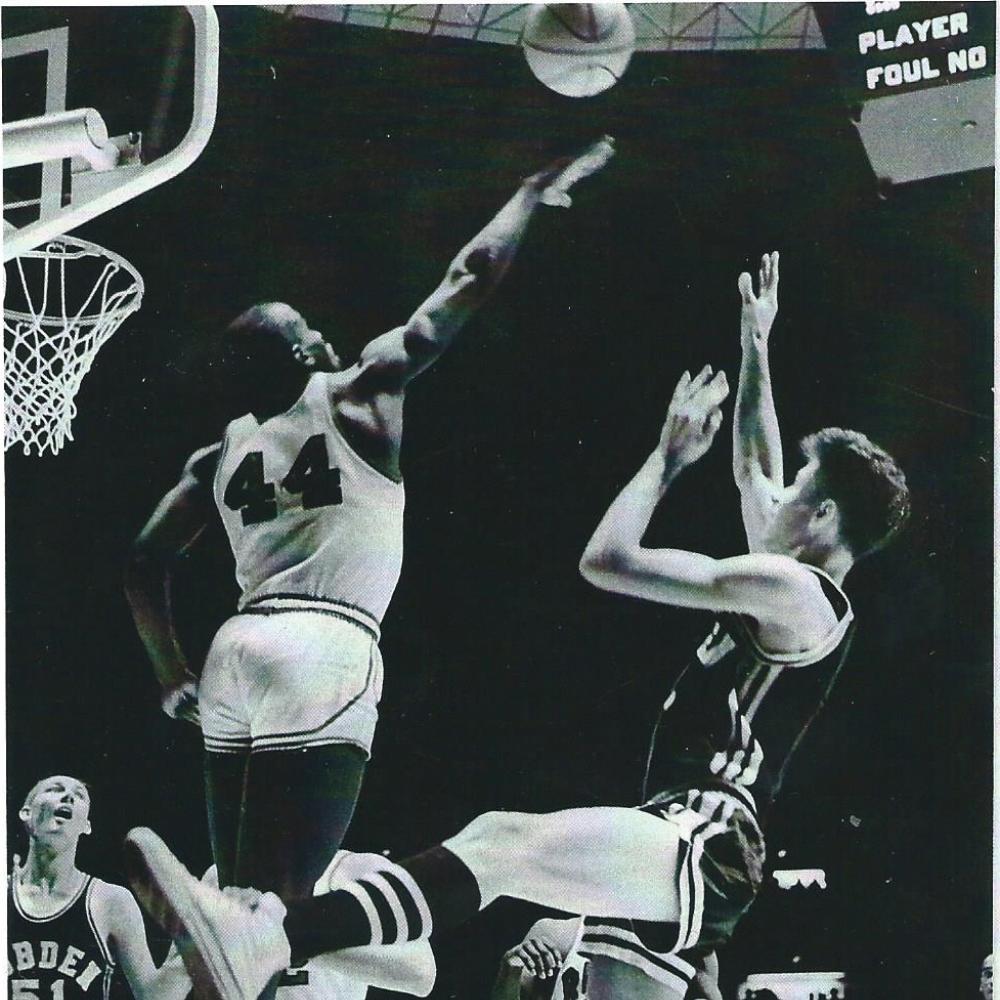 Flick shoots the basketball midjump, as Currie tries to block his shot with an outstretched arm