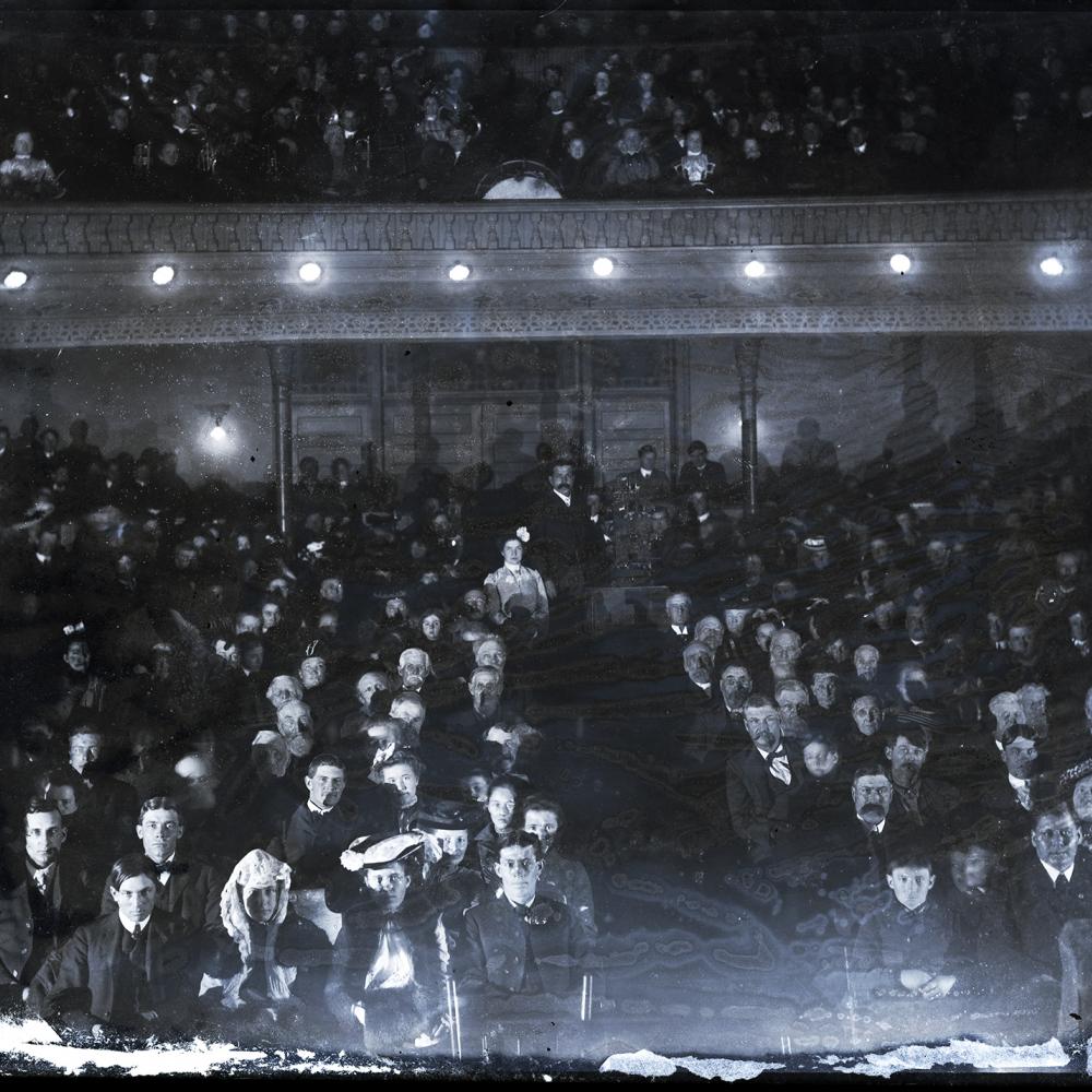 Black and white photo of an early cinema in Iowa, full of viewers.