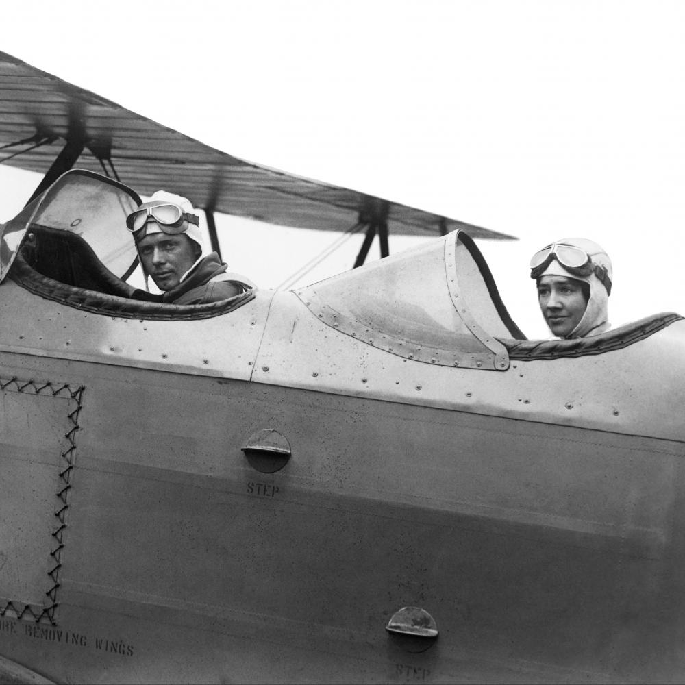 Black and white photo of the Lindbergh brothers in an airplane with an open cockpit.