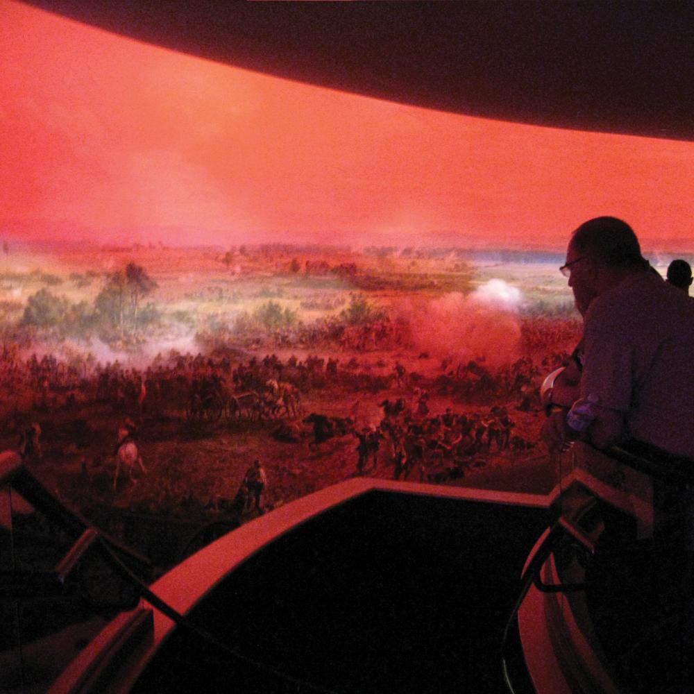 Photograph of a man viewing panoramic piece of art