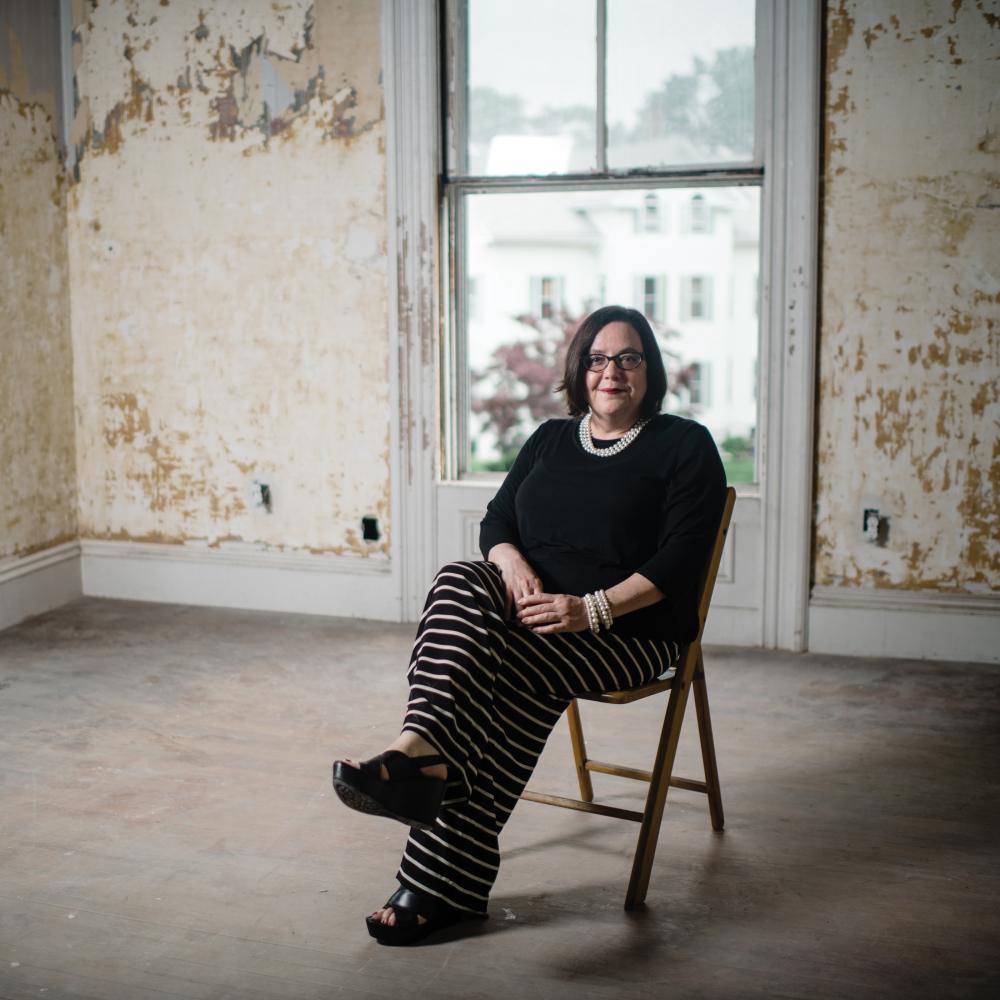 Photo of a woman sitting in a chair in an empty room