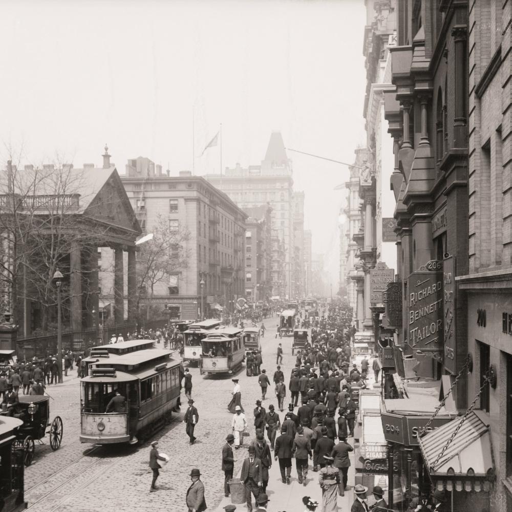 Black and white photograph of a busy city street, people on sidewalks
