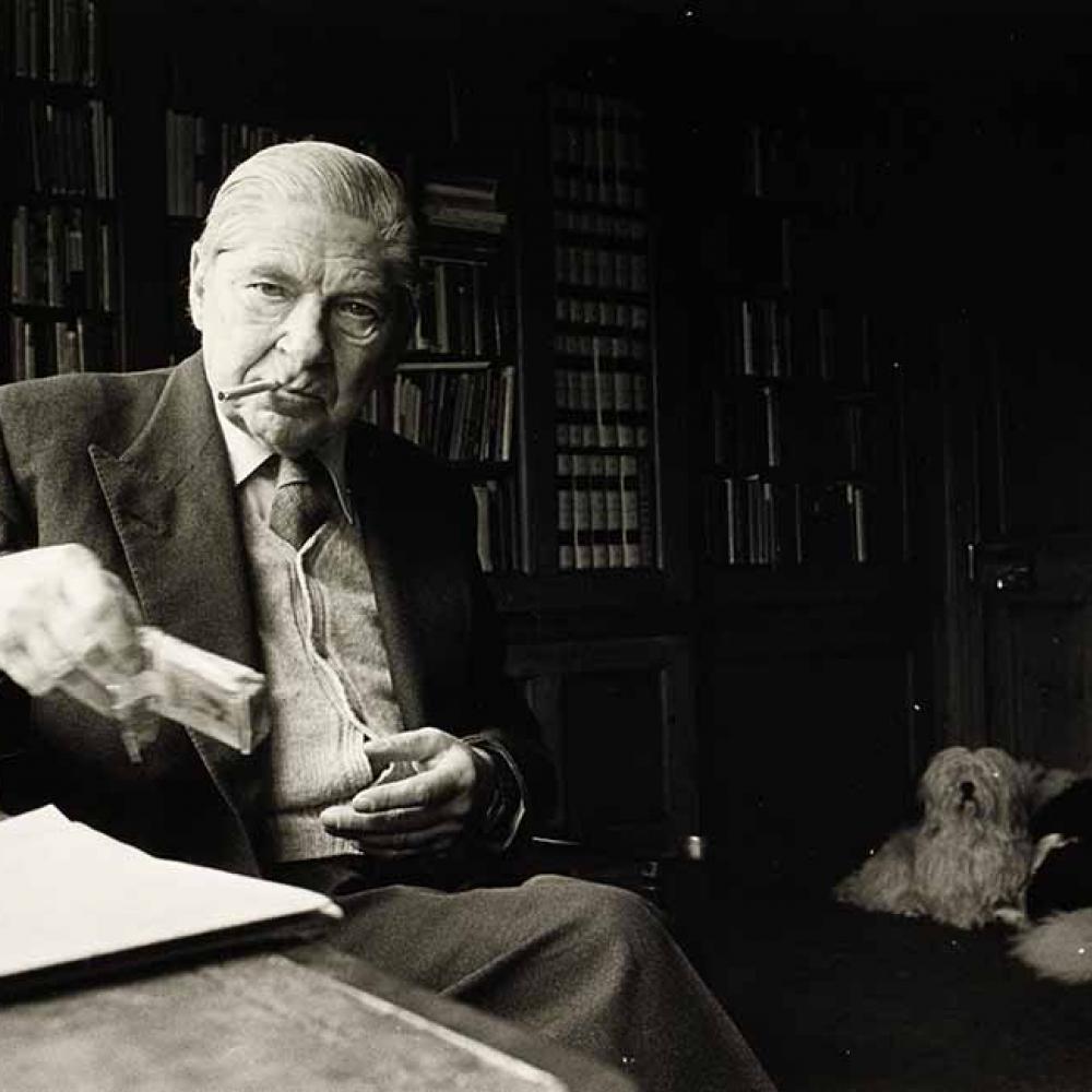 Arthur Koestler as an older man, in a study with a dog seated nearby