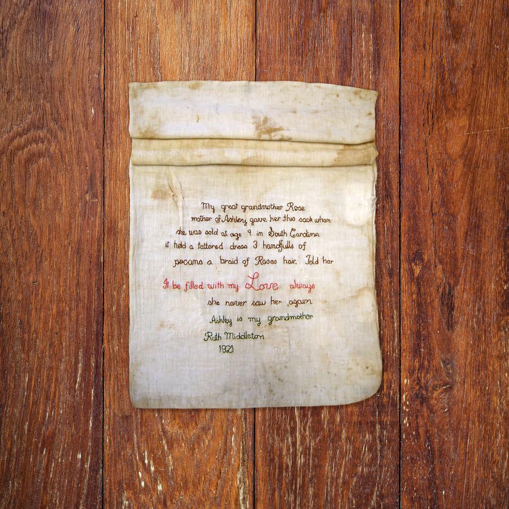 linen sack with stitched writing on top of a wood background