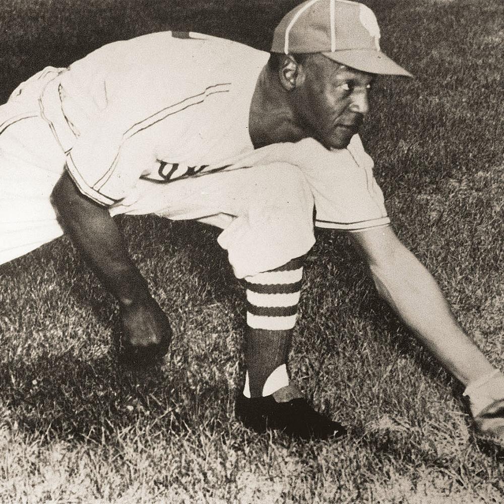 Black and white photo of Buck O'Neal reaching for a ground ball.