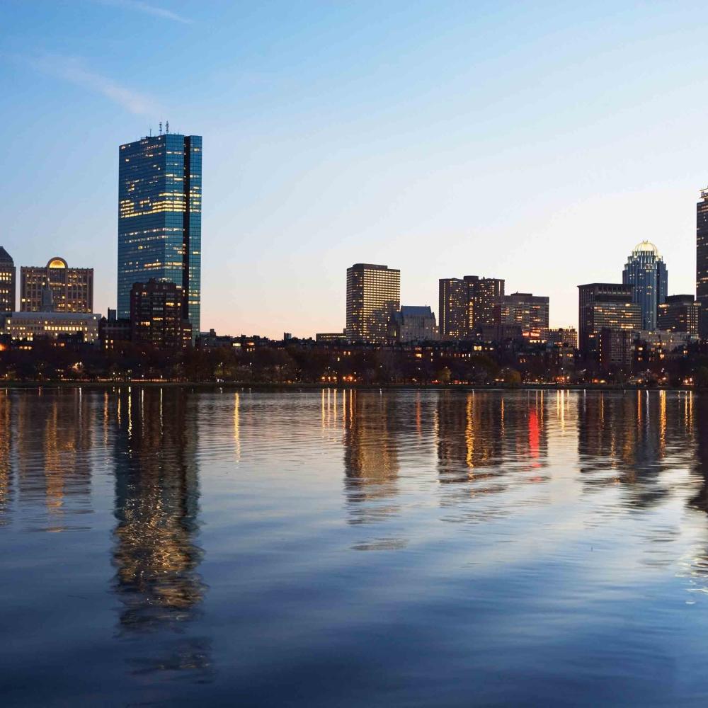 Photo of the Boston skyline reflected in the waterfront.