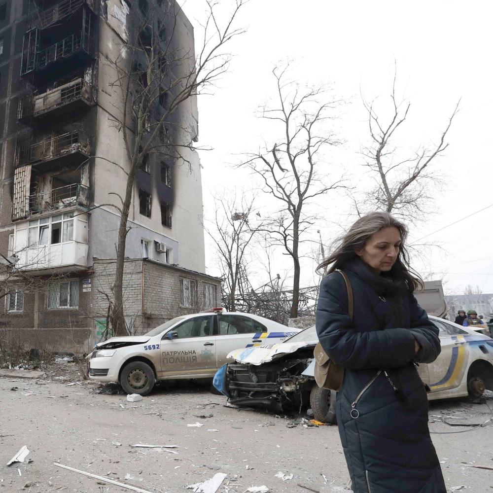 Woman walking in Mariupol, Ukraine, amidst the rubble of war. 