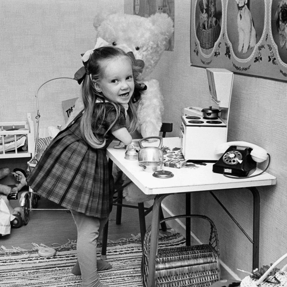 A young thalidomide victim plays in her toy kitchen.