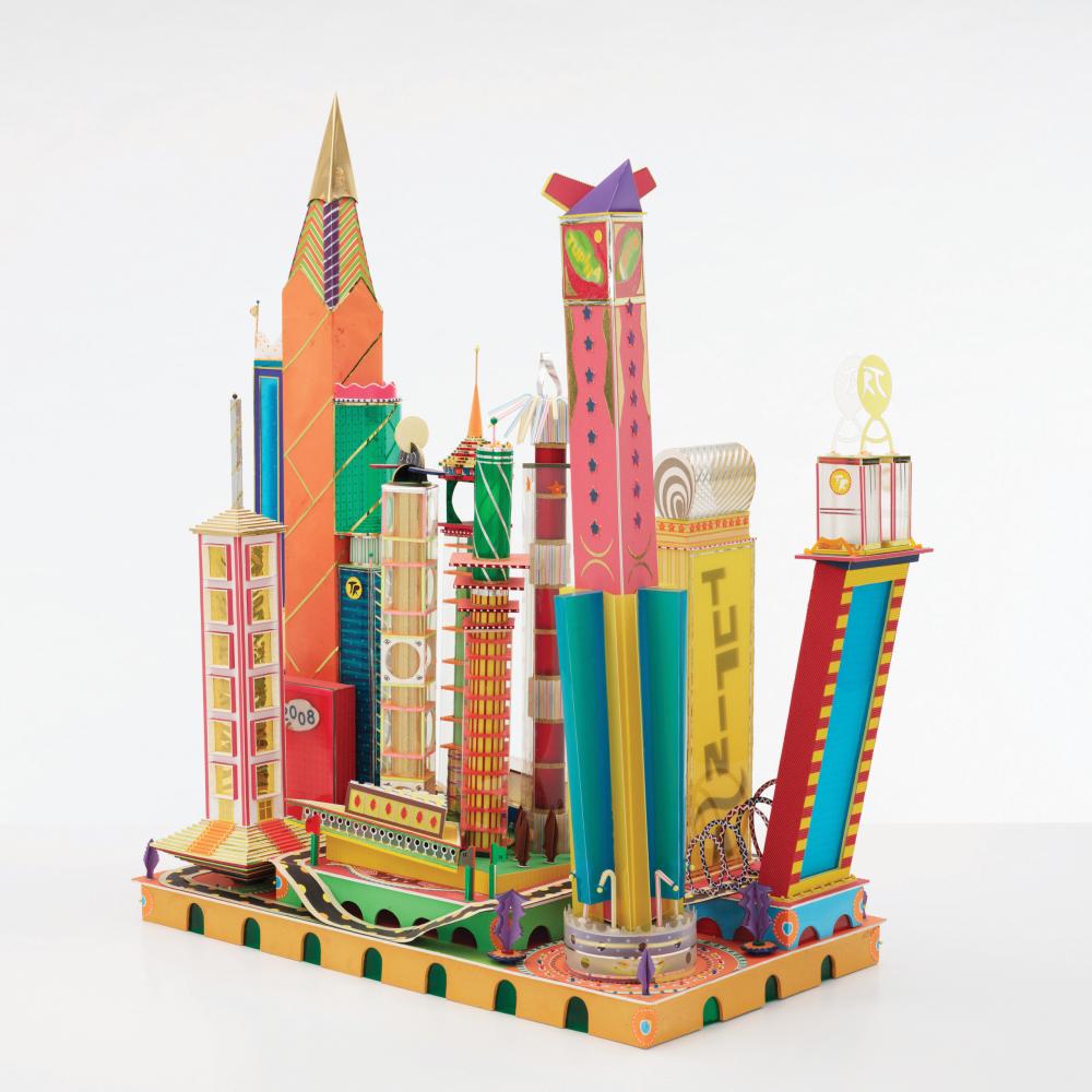 Photograph of a cityscape constructed by Bodys Isek Kingelez with approximately a dozen brightly-colored buildings.
