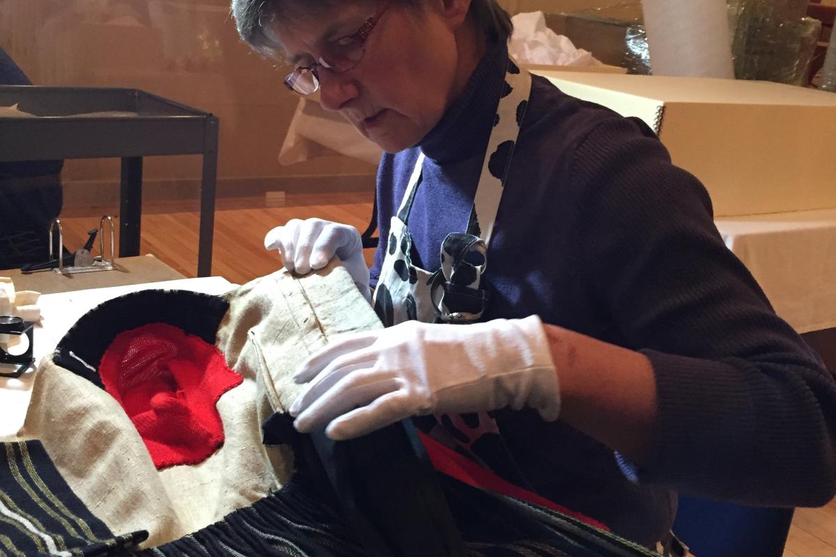 Textiles conservator Jane Hutchins reviews a National folk costume