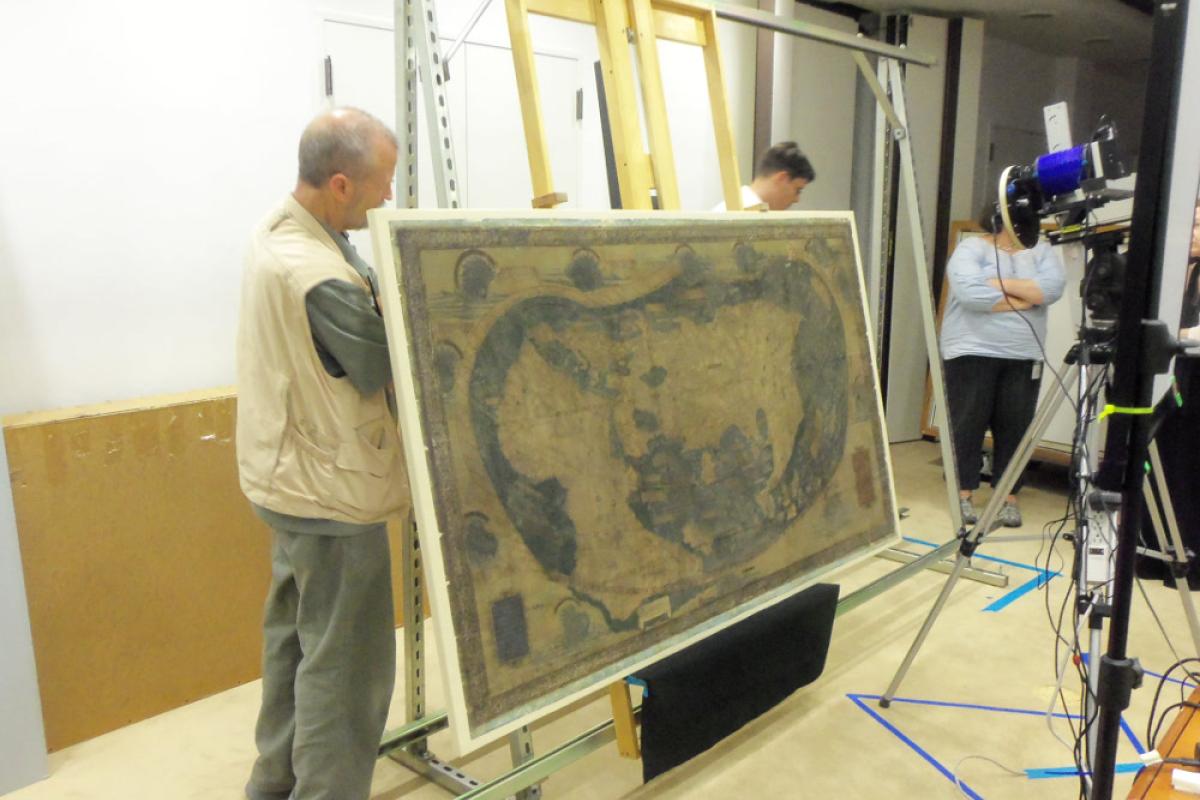 Man adjusting art stand