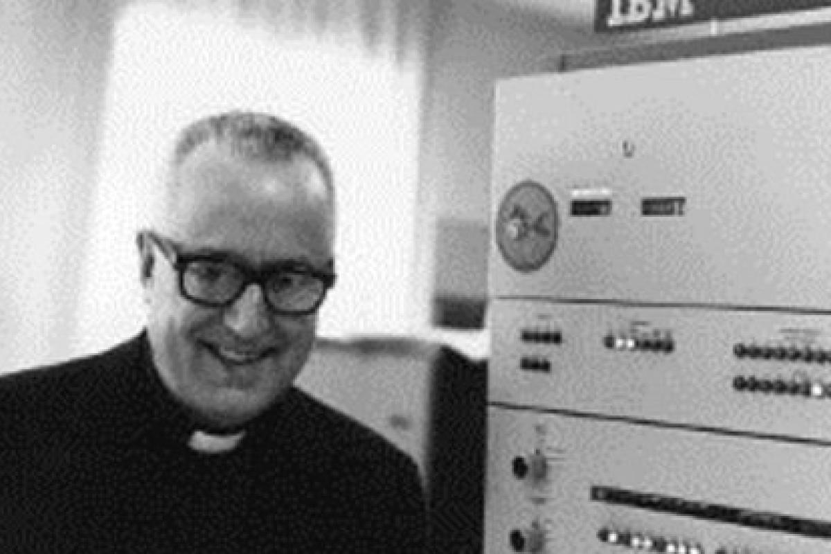 Photo of Father Roberto Busa next to a mainframe computer.