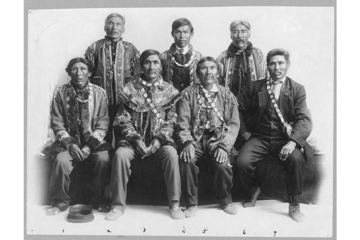 Group of Native American men, half seated, half standing up