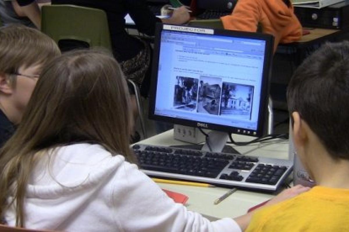 Three GeoHistorians tackling a problem on their computer screen.