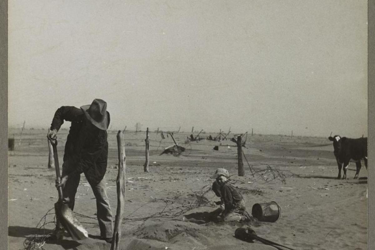 Plains farmer raises fence to prevent it from disappearing under sand.farmer