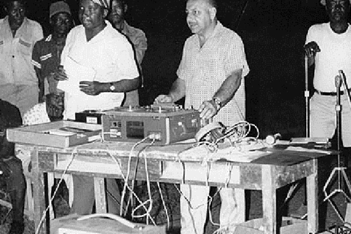 Man DJ'ing with other men around him