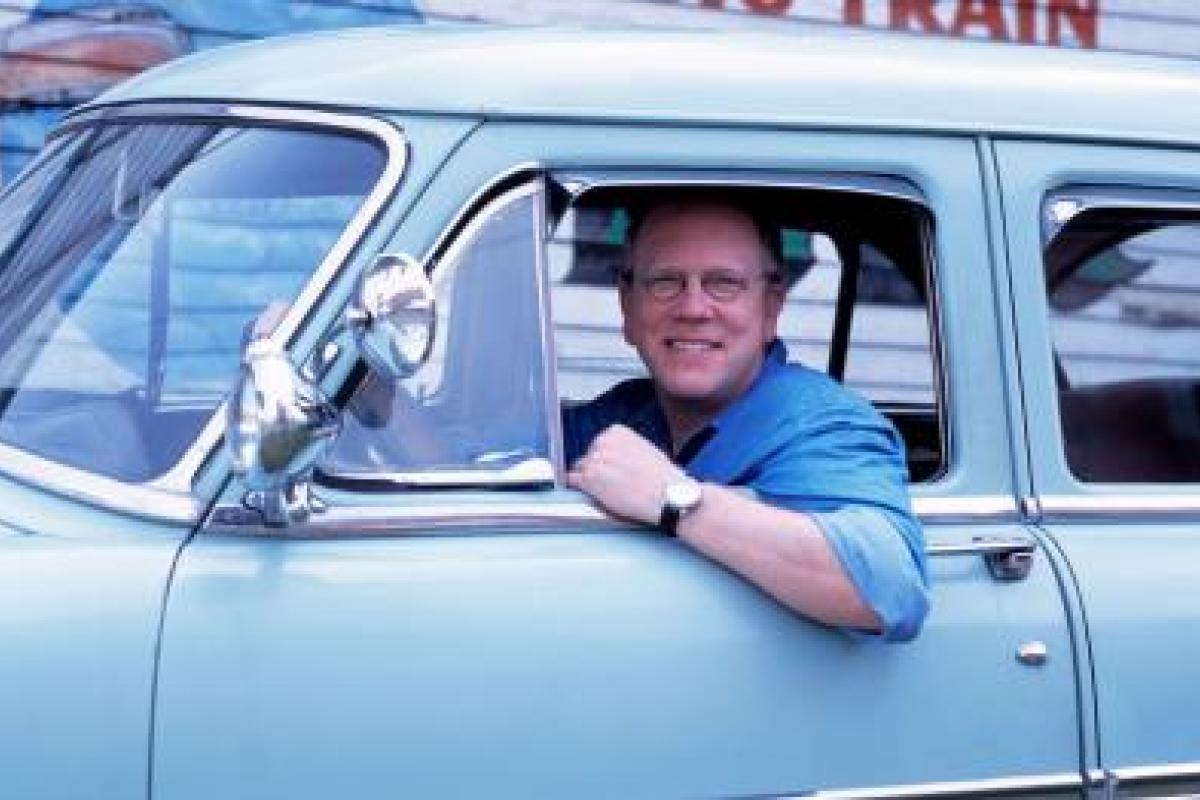Photo of Nick Spitzer, host of American Routes, in a blue car