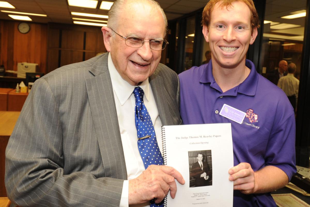 Two men holding a paper