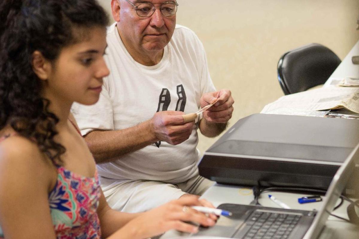 Young woman and old man at a computer