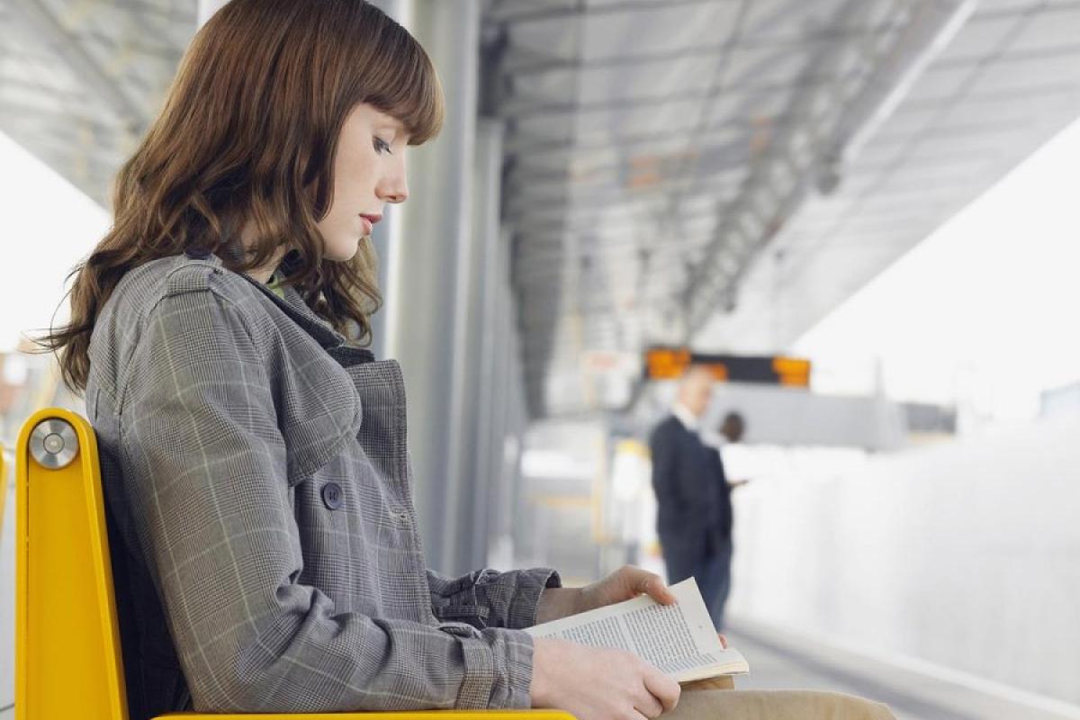 Dreamstime.com / Businesswoman Reading Book At Train Station Photo