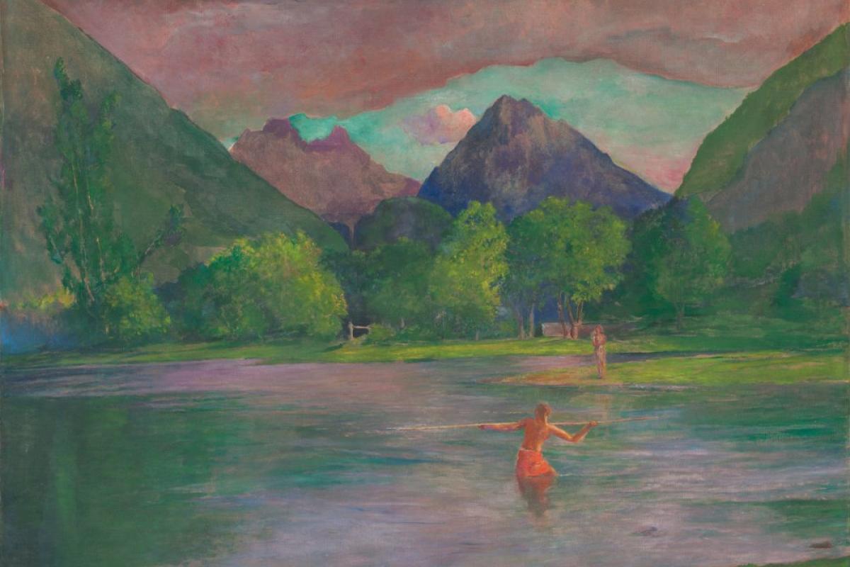 A native fisherman in the river, with mountains in the distance.