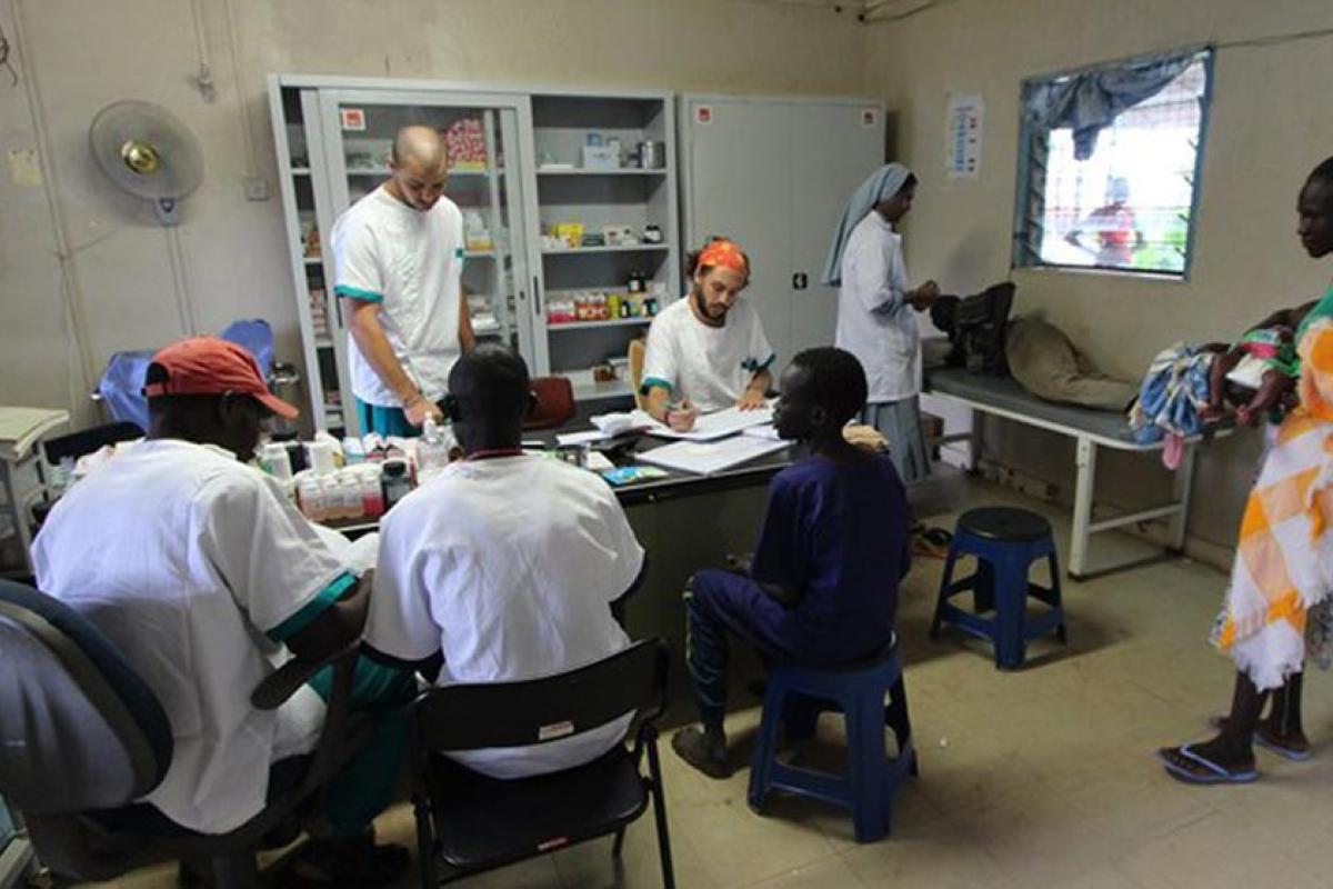Photograph of clinic with various doctors working around a table