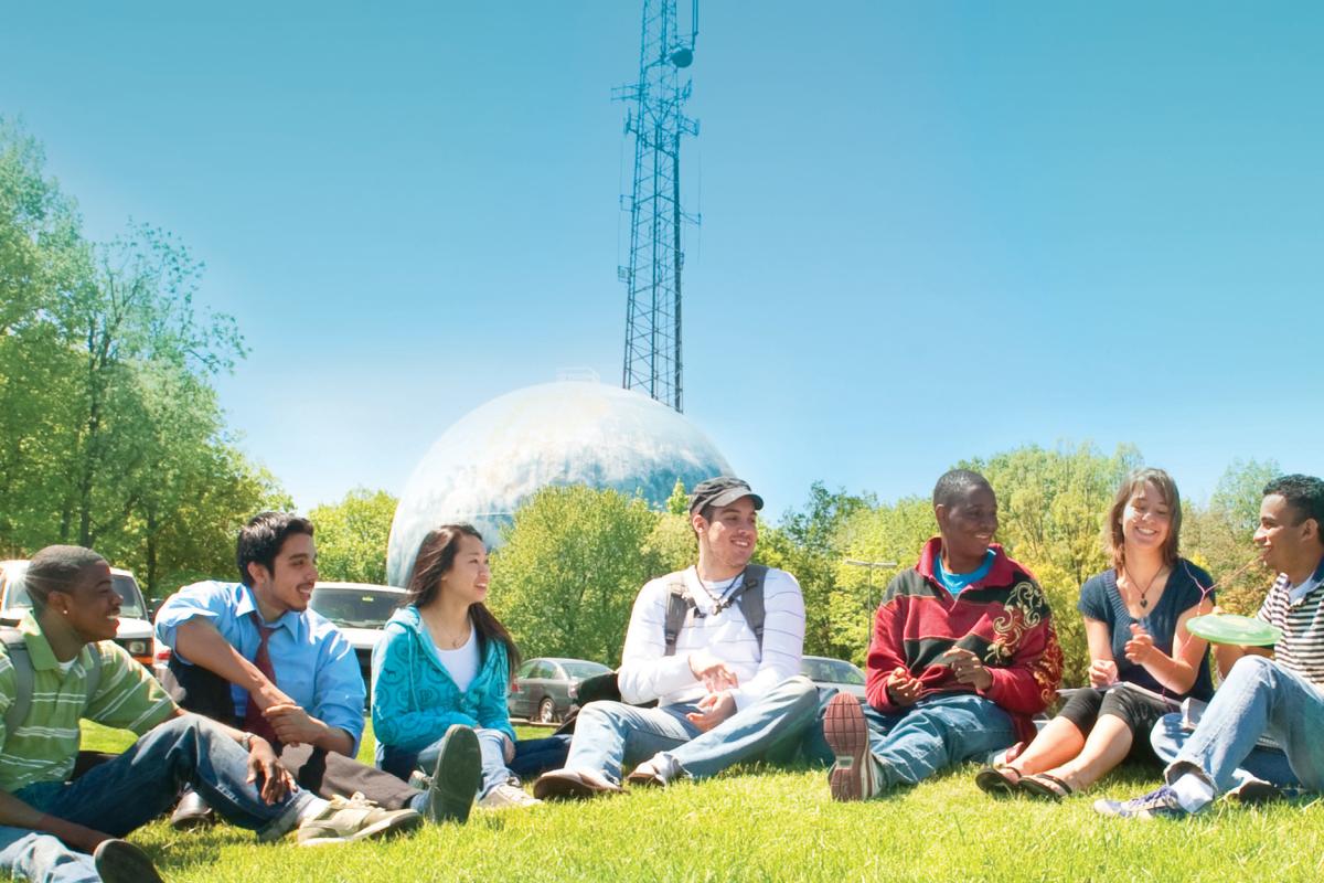 Students gather by the globe water tower on the Germantown campus to discuss the global humanities.