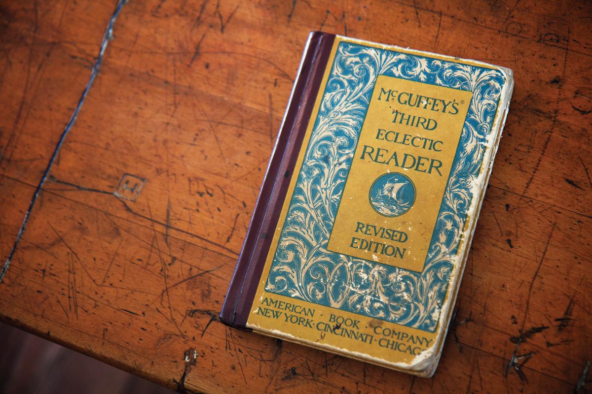 A McGuffey reader, unopened, on a wood tabletop